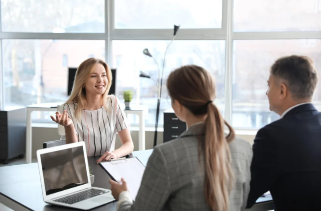 two women talking across work desk